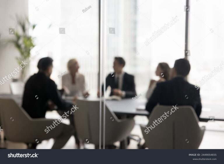 stock-photo-group-of-businesspeople-negotiating-gathered-in-modern-conference-room-blurred-silhouettes-view-2449054655